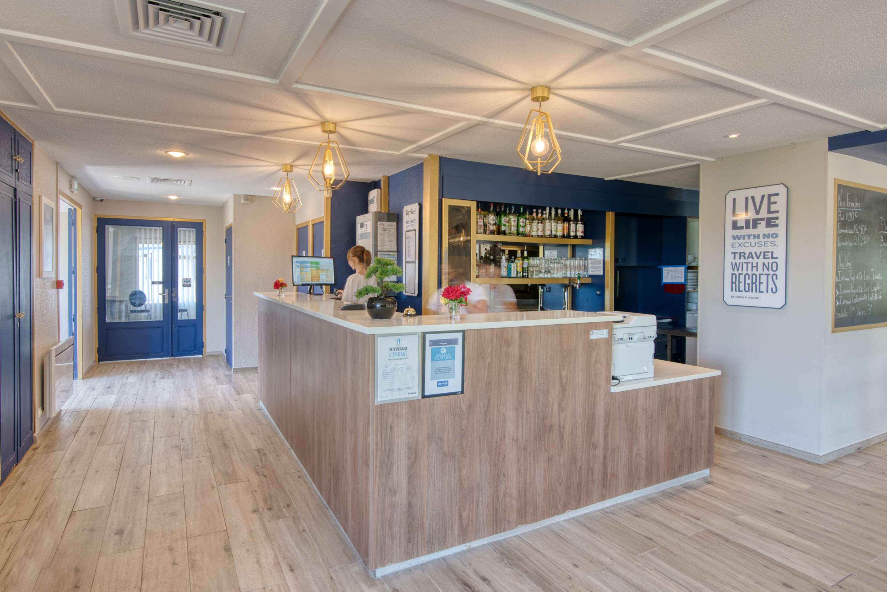 Hall d'accueil de l'hôtel avec le comptoir de réception et le bar